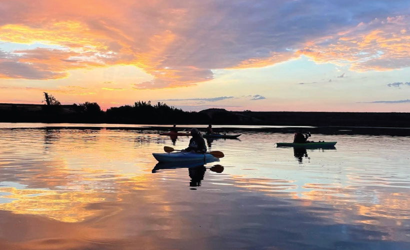 kayakers on crowder lake at picturesque sunset